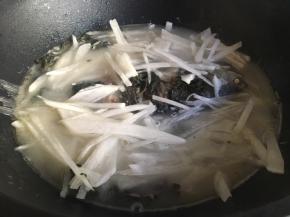 大约焖煮10分钟左右后，均匀的放入萝卜丝，盖上锅盖继续焖煮大约5分钟；