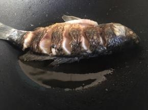煎至一面金黄，表面变硬后翻面，同样鱼头和鱼尾的位置也需要煎到，煎至两面金黄。