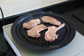 大约1分钟后，把羊排翻个面，这时候可以开始淋入调料了。