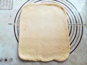 取白色面团轻轻按压掉气泡，擀成长25厘米，宽15厘米，厚度约1厘米的面皮