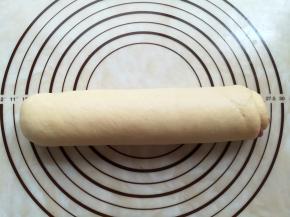 面团从下往上卷起来。收口的地方捏紧朝下放