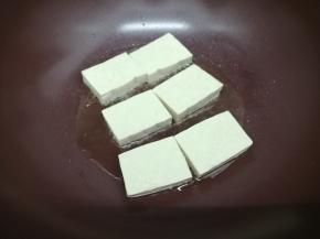 锅里加入适量的油，烧到七成热时，把豆腐摆在锅中