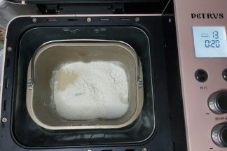 除黄油、盐之外的全部面团材料放入面包桶内，启动面包机IMIX程序。（柏翠面包机直接设置一次IMIX程序，其它面包机可以设置和面程序20分钟）