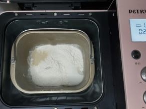 除黄油、盐之外的全部面团材料放入面包桶内，启动面包机IMIX程序。（柏翠面包机直接设置一次IMIX程序，其它面包机可以设置和面程序20分钟）