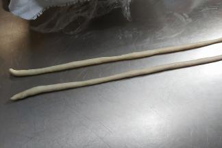 取出两块小面团，轻轻搓成两头尖的长条。