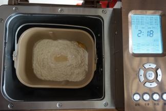 在面粉顶端加入酵母，将面包桶放入到面包机里，选择甜面包程序，时间显示2小时18分钟（不同型号的面包机制作时间有所不同）