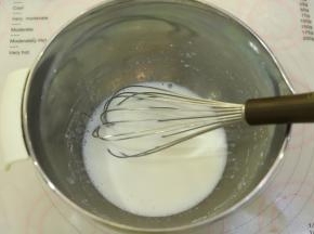 玉米油和牛奶用手动打蛋器混合乳化。