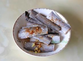 带鱼解冻洗净，去内脏，放油、盐、生粉、生姜、胡椒粉拌均。