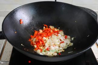 煎鱼剩下的油锅，倒入辣椒、大蒜、大葱用旺火爆香，放入炸好的带鱼。