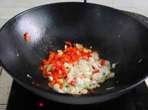 煎鱼剩下的油锅，倒入辣椒、大蒜、大葱用旺火爆香，放入炸好的带鱼。