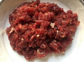 将牛肉洗干净之后放在清水当中进行浸泡，浸泡的时间为一个小时左右，这样是为了让牛肉当中的血水和杂质能释放出来，而且能使纤维软化一些牛肉用清水浸泡15分钟左右，然后逆着纹路切成丝备用；