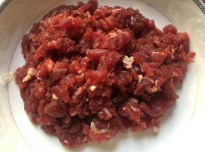 将牛肉洗干净之后放在清水当中进行浸泡，浸泡的时间为一个小时左右，这样是为了让牛肉当中的血水和杂质能释放出来，而且能使纤维软化一些牛肉用清水浸泡15分钟左右，然后逆着纹路切成丝备用；