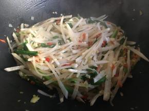 不停翻炒，炒至白萝卜丝变软变透明，炒至大约八分熟