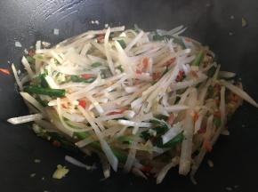 不停翻炒，炒至白萝卜丝变软变透明，炒至大约八分熟