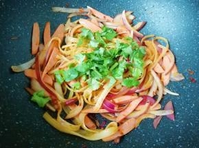 下入火腿肠翻炒均匀关火，最后撒入香菜利用锅的余温翻炒均匀。