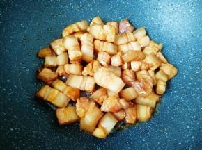 下入五花肉煸炒上色。