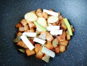 下入葱、姜、八角和香叶炒出香味。