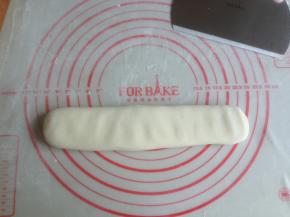 将松驰过的面团搓长，然后压扁