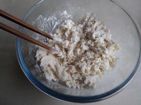 和面盆里装入面粉、糖，可以加一点奶粉，大概10克。倒入酵母牛奶液，用筷子拌成絮状