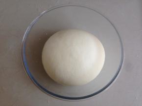 用手揉成光滑的面团。我一般是先将它揉成比较粗糙的面团，静置5分钟后再揉，就很轻松地揉光滑了。和面盆上盖上保鲜膜，面团在室温下发酵两倍大。如果室温偏低，可以将面团放入烤箱或密封的空间，加一碗热水，使里面的温度升高，加快面团发酵的速度