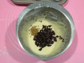 用手动打蛋器之字形混合，无干粉即可，略有颗粒也没有关系。然后放入葡萄干碎和干桂花。