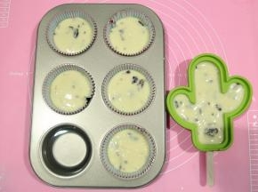 用刮刀，翻拌几下即可。然后倒入提前准备好的裱花袋中（裱花袋套在杯子上，翻开袋口比较容易操作），取下袋子，拧紧袋口，裱花袋前端，剪口，不需要特别大，不过也不要很小，不然葡萄干碎过不去。挤入连模中。如果连模没有放满，记得加点水一起烤，不要空烤。