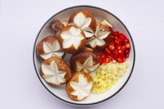 香菇去蒂切米字花刀， 姜蒜切末，红椒切圈。