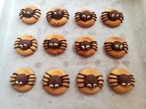 换白色巧克力画出蜘蛛的眼睛，最后用黑巧克力点出眼珠，蜘蛛曲奇饼干就做好了