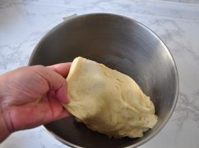 揉至面团光滑时，加入黄油和盐，继续揉。