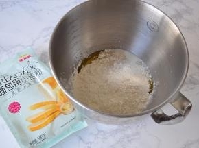 将黄油、盐除外的全部材料，面粉、牛奶、蛋液、糖，酵母按顺序放入盆内。您可以用面包机，也可以用厨师机，或者用手揉。每种面粉的吸水率不同，所以水要预留出10克，根据面团实际情况增减。我用的是金龙鱼面包用小麦粉，它是以100%优质进口小麦为原料，筋力高，做出的面包组织细腻，口感松软，弹性足，不仅适用于面包机面包的制作，也适用于各种手工面包的家庭制作， 我一直使用它。