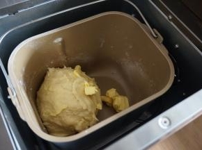第一次和面结束后，加入切成小块的黄油，继续和面13分钟，不同型号的面包机揉面时间不同