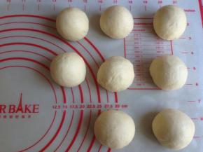 发酵好的面团取出，轻压排气，分成8等份，滚圆，盖保鲜膜松驰15分钟