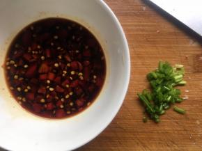 煎豆腐期间，调酱汁；碗中倒入生抽、糖、剁辣椒、小半碗水，搅拌均匀，葱花切碎；