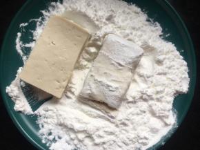 再将一块块豆腐先裹上一圈淀粉；