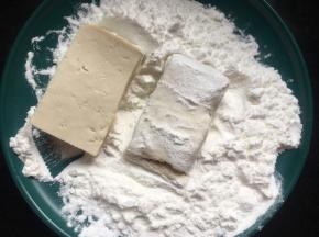 再将一块块豆腐先裹上一圈淀粉；