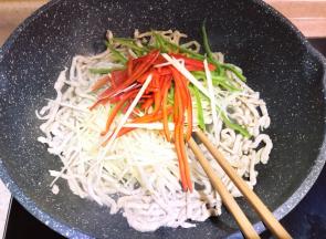 大火炒至肉丝变白，料酒味全挥发时放入仔姜和青红椒丝。