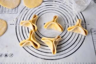 先用手提成三角状，在中间轻捏一下，然后用筷子把三个边缘夹一下，要夹紧哦！否则蒸时会渗糖。