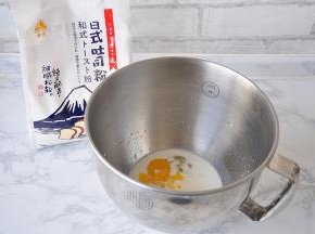 先将液体类的食材放在盆中。然后加入炼乳、糖，混合一下。请注意，盐和黄油不要放入！液体的量可以微调，牛奶一般预留出10-15克来，以便随时调整面团的软硬度。不必刻意鸡蛋是55克还是50克，鸡蛋不够，牛奶来凑，它与牛奶的加起来的量就行。