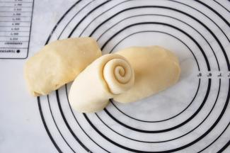 翻面，从一端卷起。卷起时第一卷稍稍按压固定，并顺势卷起。捏紧底部。擀卷不要太紧，也不要留空隙。一般以2.5-3圈为宜。