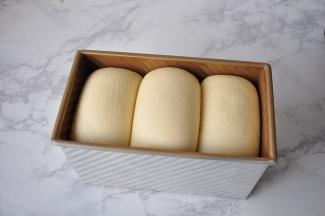 利用烤箱的发酵模式，进行最后发酵。烤箱自带的发酵温度是35度，我们可以在烤箱底部放一盘热水，既能制造出吐司发酵所需要的温度，又能创造出所需要的湿度。发至9分满。