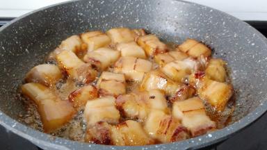 加五花肉迅速翻炒上色。