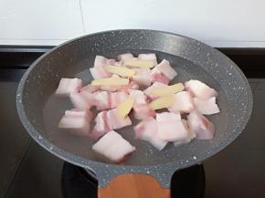 五花肉凉水下锅加料酒，生姜焯水。