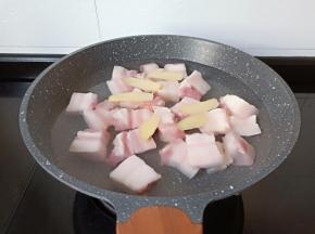 五花肉凉水下锅加料酒，生姜焯水。
