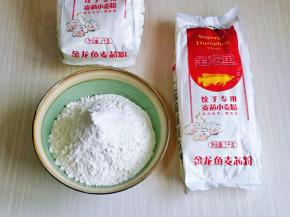 首先将饺子粉称重，放入大口器具中，加入盐。(今天包饺子选用的是金龙鱼饺子专用麦芯小麦粉，采用精选优质小麦，取麦芯的精华，饺子粉吸水性特别好，颜色也好看，揉面时的手感特别好，忍不住想多揉一会儿)