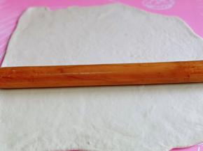 这时面团也醒好啦，硅胶垫上撒点干粉，用擀面杖擀一大张面饼。