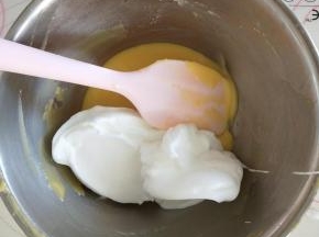 6、去1/3蛋白与蛋黄糊混合，用切拌和翻拌的手法混合均匀。
