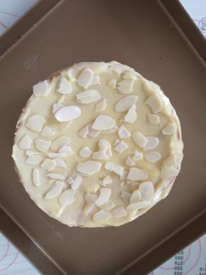 12、取出蛋糕放在烤盘上，将奶酪糊涂在蛋糕表面（撒杏仁片）和四周，再送入烤箱，只开上火200-230度，烘烤5分钟，表面上色即可