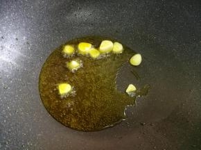 锅内放入适量的油，油温五六成热时，加入大蒜爆香。
