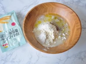 将面粉与橄榄油、盐、糖、酵母、水、藜麦放在一起。水要留10克，根据面团实际情况增减。我用的是金龙鱼面包用小麦粉，它是以100%优质进口小麦为原料，筋力高，做出的面包组织细腻，口感松软，弹性足，不仅适用于面包机面包的制作，也适用于各种手工面包的家庭制作， 我一直使用它。