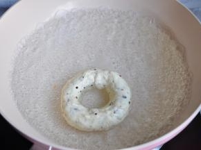 锅中加入1000毫升的水，50克的糖烧开，注意煮的时候要就要提前开始预热烤箱了。 将贝果每一面煮40秒。